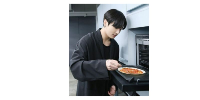 Jungkook sedang memasak di dapur