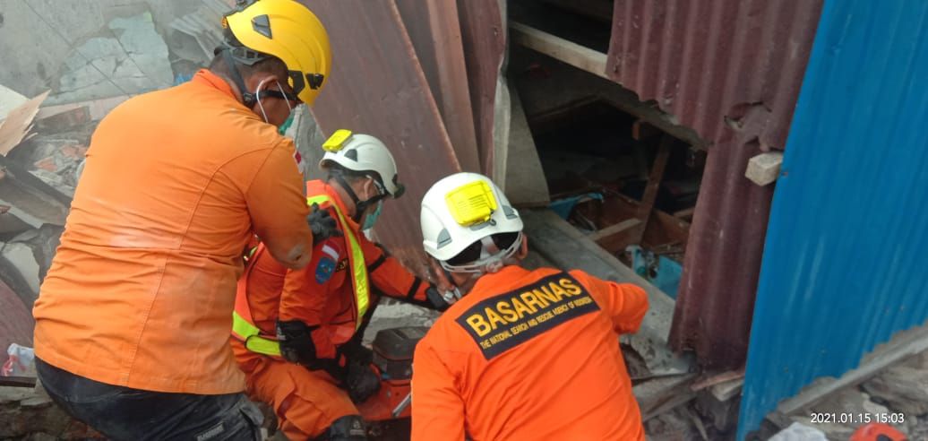 Tim Basarnas sedang berusaha mengevakuasi korban yang tertindih reruntuhan bangunan akibat gempa bumi berkekuatan 6,2 skala richter di Sulawesi Barat, Jumat 15 Januari 2021.*