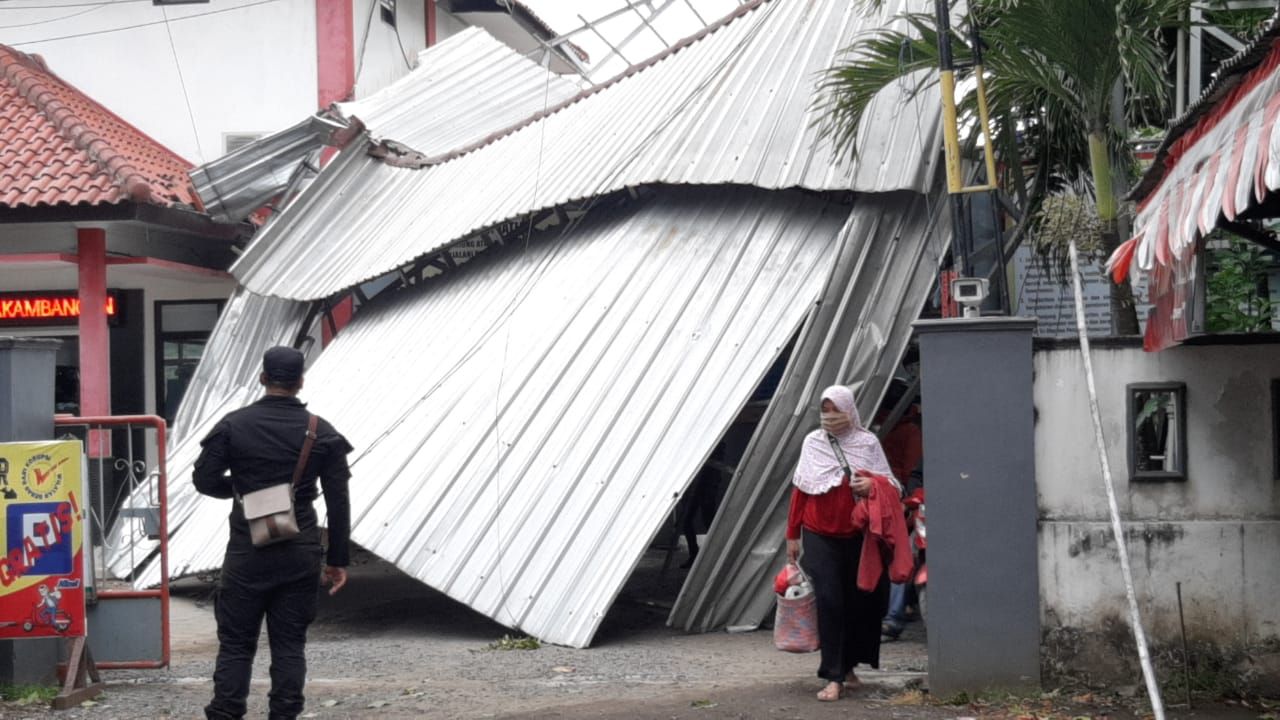 Warga yang bekerja di Pulau Nusakambangan berjalan kaki melewati atap Pos Dermaga Wijayapura yang ambruk akibat angin kencang, Rabu, 27 Januari 2021