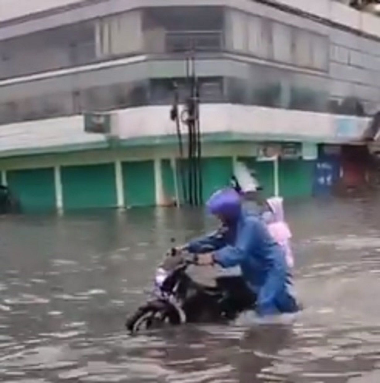 Seorang pengendara motor terpaksa mendorong motornya karena banjir di Semarang