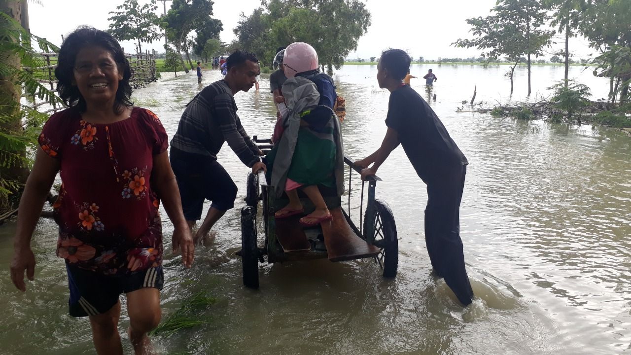 Sekelompok Pemuda Dusun Cipaku Desa Jatitengah kecamatan Jatitujuh Membantu menarik gerobak untuk menyebrangkan pengendara yang terjebak banjir, Selasa 8 Februari 2021