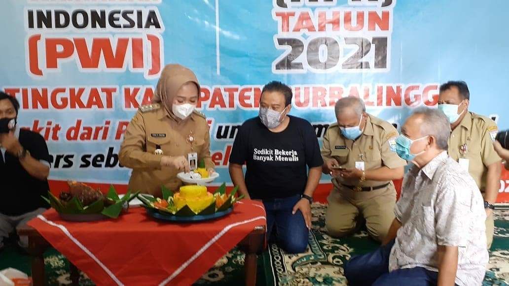 Bupati Purbalingga Dyah Hayuning Pratiwi didampingi Ketua PWI Purnalingga Joko Santoso memotong tumpeng tasayakuran HPN dan Hut PWI ke 75 di Bale Wartawan, Selasa 9 Februari 2021.