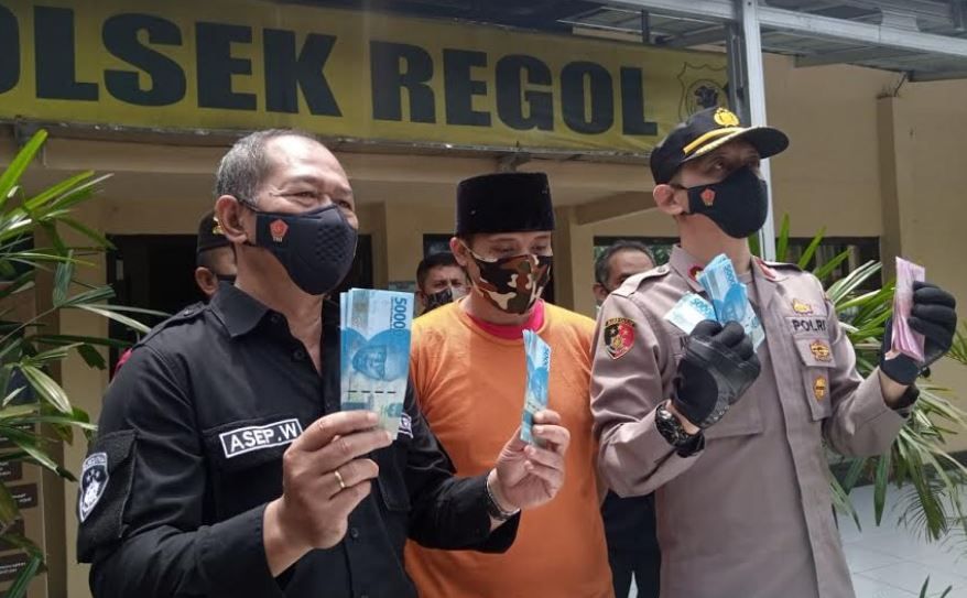 Kapolsekta Regol Kompol Aulia Djabar didampingi Kanitreskrim Regol AKP Asep Wahyudin sedang memperlihatkan uang palsu yang dibawa tersangka Rahmat Tulloh (24) yang digunakan untuk menyewa PSK di Mapolsekta Regol di Jalan Moh Toha, Kota Bandung pada Selasa 16 Februari 2021.