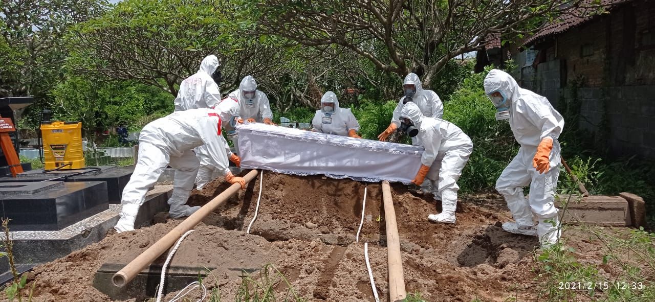 Proses pemakaman jenazah COVID-19 oleh para relawan.