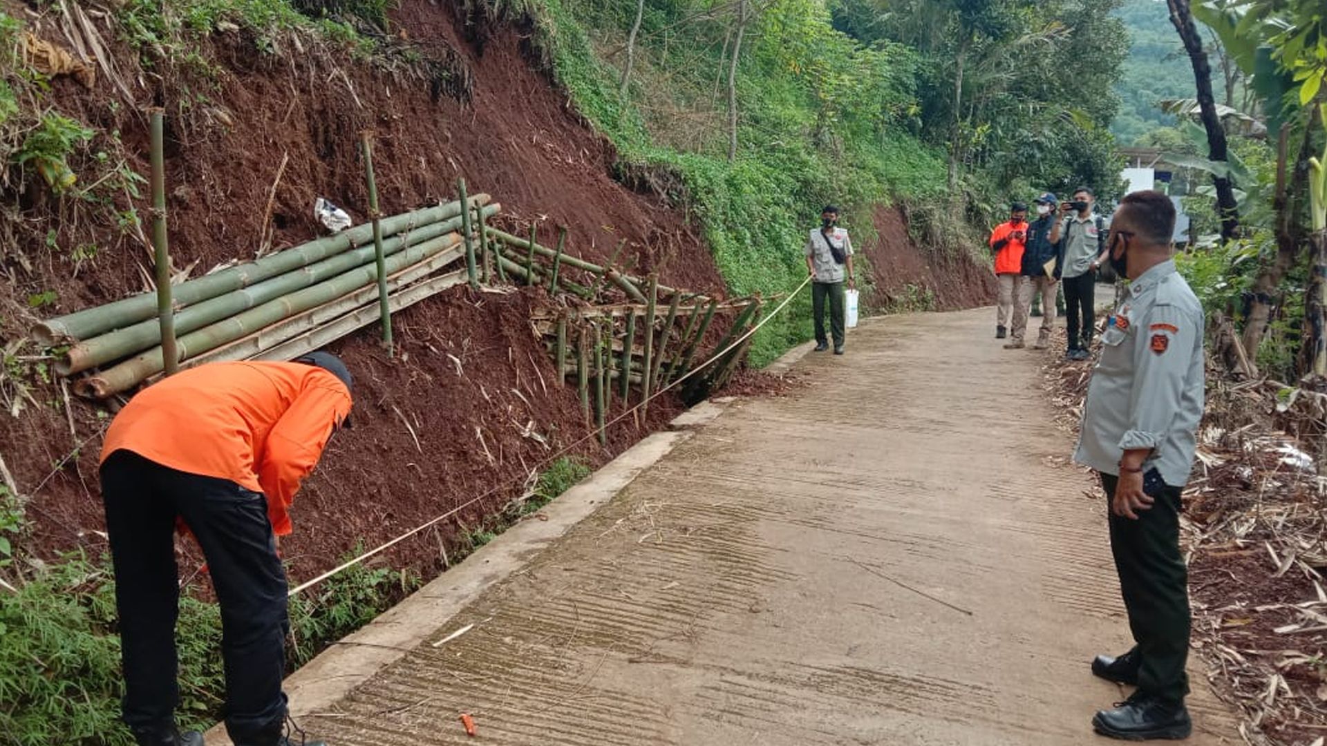 Petugas bersama warga membuat penahan lereng agar tidak terjadi longsor susulan di Desa Kutawaringin, Kabupaten Bandung, Rabu 24 Februari 2021