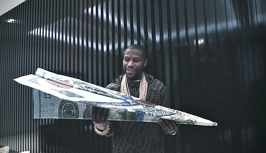 Mantan petinju Floyd Mayweather dengan koleksi 'karya seni' terbarunya, uang 100 dolar AS raksasa berbentuk pesawat terbang.