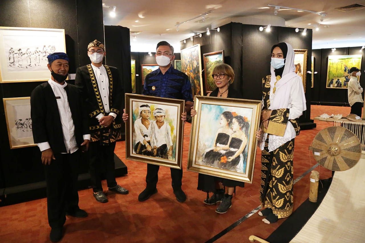 Jenny Mahastuti memerikan lukisan Sketsa Masyarakat baduy kepada Wakil Gubernur Banten Andika Hazrumy.