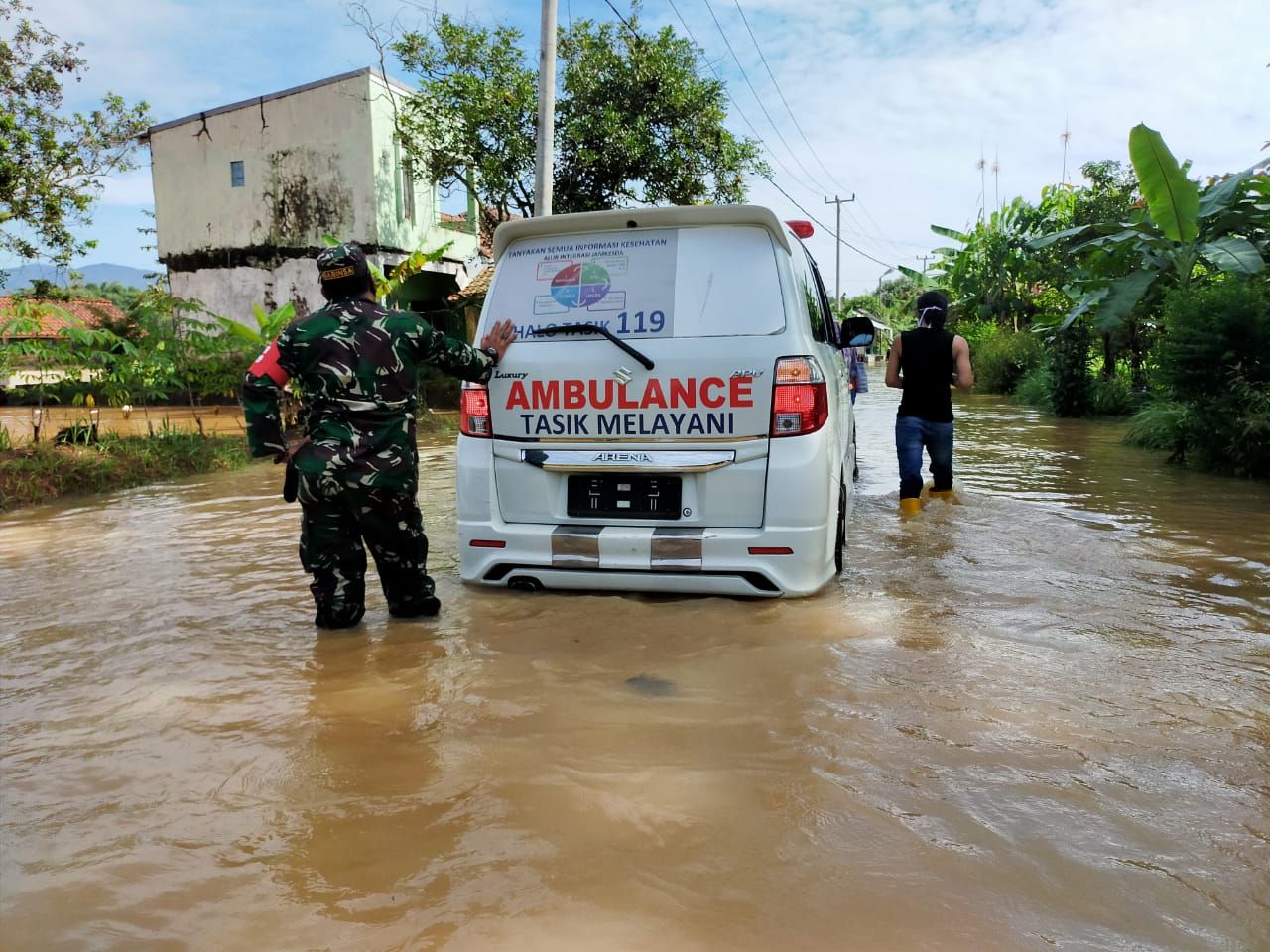 Ambulans Puskesmas Sukaresik didorong anggota TNI saat menerbos banjir untuk laksanakan vaksinasi  kepada lansia yang sudah menunggu.
