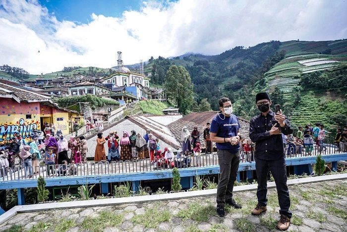 Menteri Sandiaga berfoto dengan latar belakang Dusun Wisata Kaliangkrik Nepal Van Java di Magelang yang lagi viral, dalam kunkernya di lokasi Sabtu 3 April 2021.