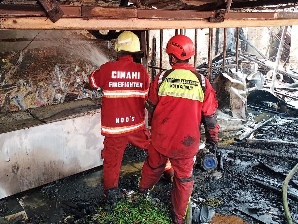 Petugas Pemadam Kebakaran Kota Cimahi melakukan pendinginan di lokasi kebakaran Rumah Makan Padang, Jalan Cihanjuang, Kota Cimahi