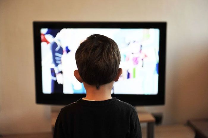 Ilustrasi seorang anak sedang menonton siaran televisi