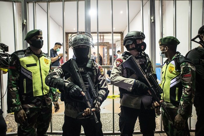 Personel kepolisian bersenjata dan prajurit TNI berjaga saat tim Densus 88 Antiteror melakukan penggeledahan di bekas markas Front Pembela Islam (FPI), Petamburan, Jakarta, Selasa 27 April 2021