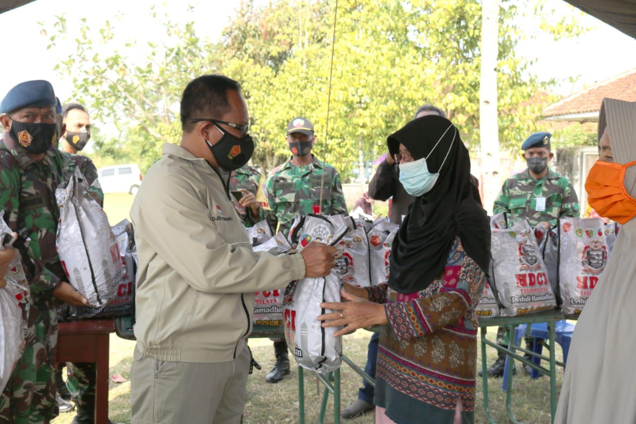 Seorang ibu menerima paket sembako bantuan TNI, Polri dan HDCI Tasikmalaya.