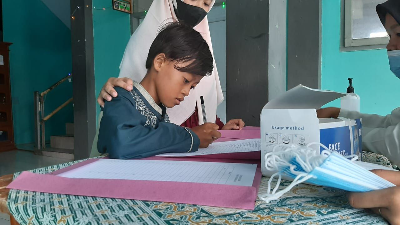 Salah seorang anak yatim membubuhkan tanda tangan bukti penerimaan santunan dan uang kadeudeuh dari lembaga pendidikan Nurul Falah.