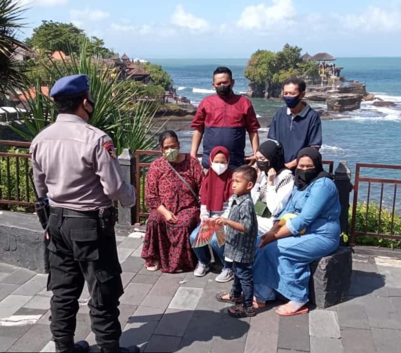 Polisi Polres Tabanan berikan imbauan protokol kesehatan di Obyek Wisata Tanah Lot, Tabanan, Bali.