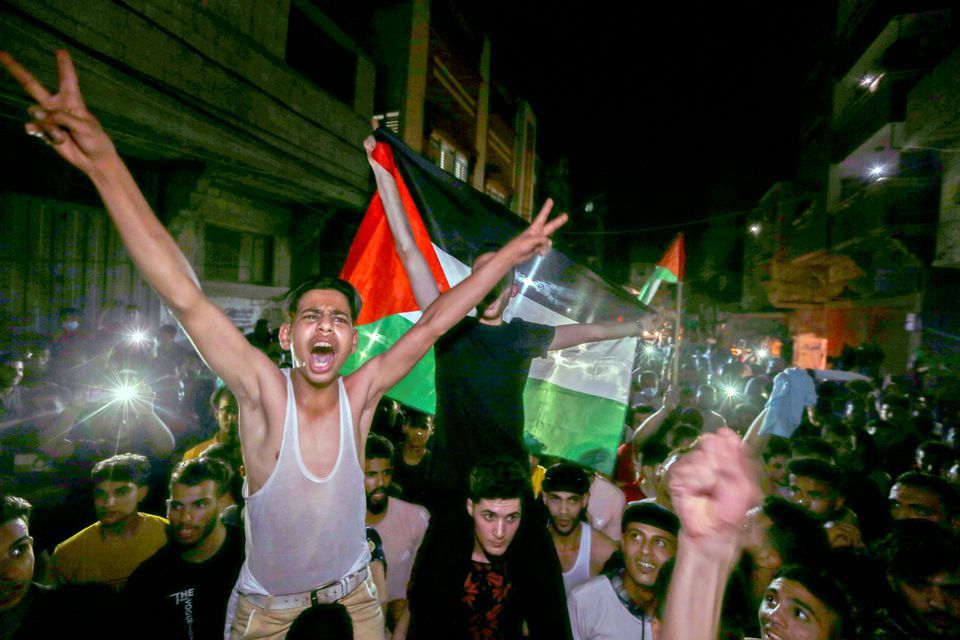Warga Palestina merayakan di jalan-jalan setelah gencatan senjata, di Jalur Gaza selatan pada Jumat, 21 Mei 2021/Reuters/Ibraheem Abu Mustafa