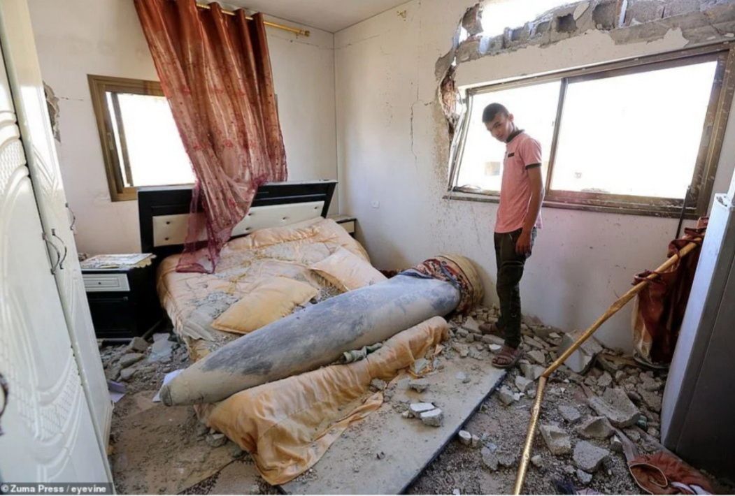 Warga Palestina melihat rudal Israel yang gagal meledak dari sebuah rumah di Khan Yunis, di Jalur Gaza selatan, pada 20 Mei 2021.  