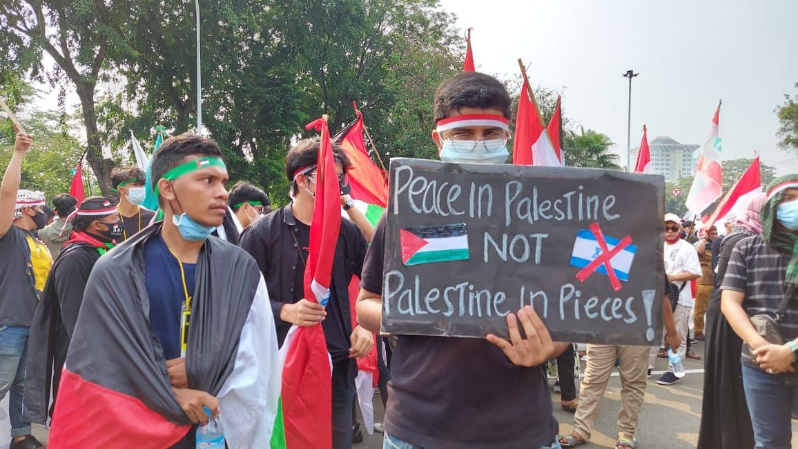 Poster dengan tulisan saat aksi demo bela Palestina di depan Kedubes AS di Jakarta