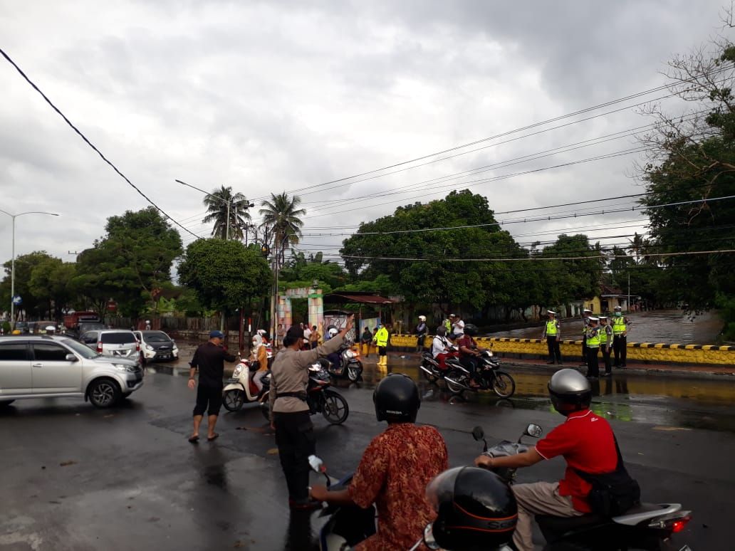 Sejumlah pihak kepolisian menjaga ruas JL Letjen S. Parman untuk menertibkan dan memecah kemacetan lalu lintas akibat luapan sungai Bagong, Kabupaten Banyuwangi 