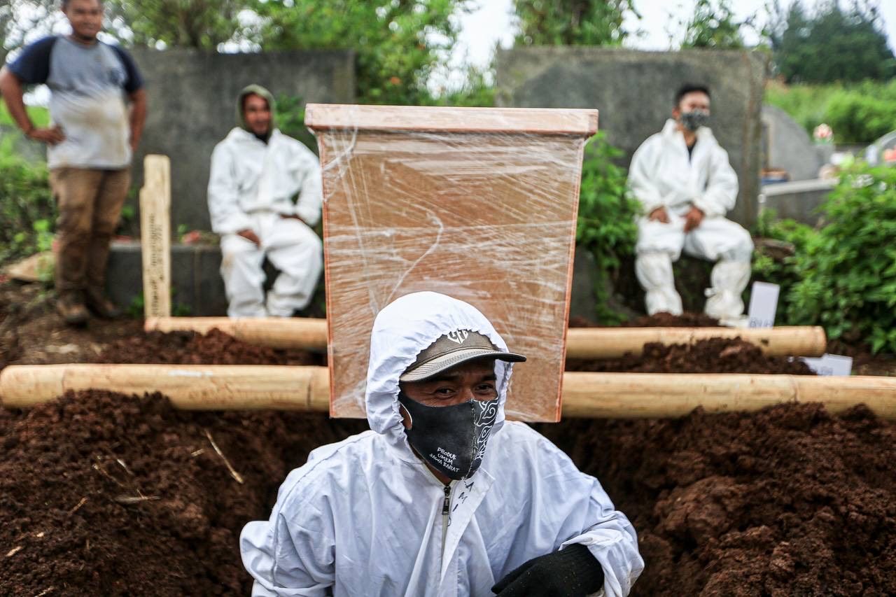 Petugas menguburkan jenazah Covid-19, di TPU Cikadut, Kota Bandung