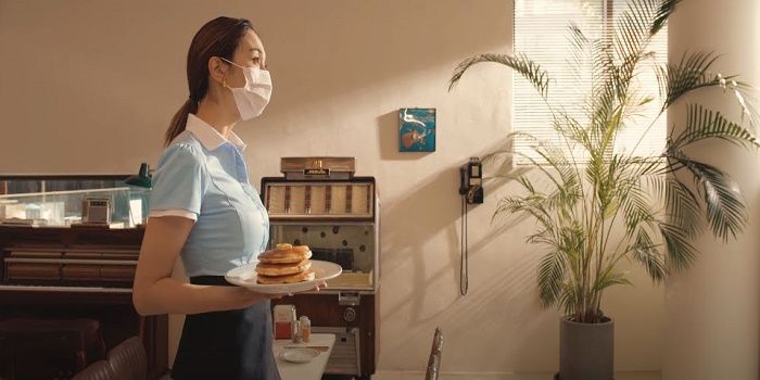 Leah Kim Thompson berperan sebagai sosok pelayan cantik yang berjalan menggunakan masker dalam MV Permission to Dance, BTS