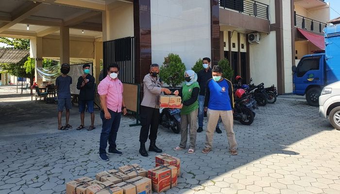 Wakapolres Wonogiri, Kompol Kamiran (dua kiri) memberikan paket sembako ke petugas dapur umum Isoter di Gedung PGRI Wonogiri