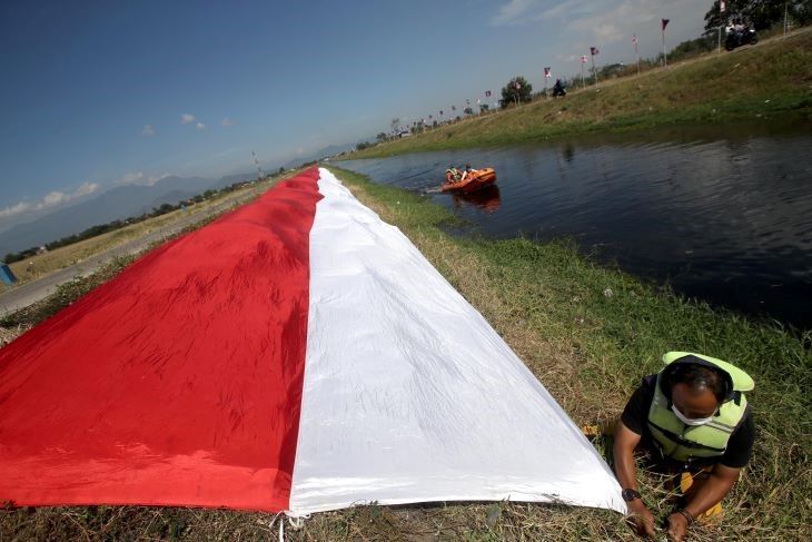 Pasukan Susur Sungai dan Ekosistem Rancaekek (PASSER) bersama anggota Pramuka Kwartir Ranting Rancaekek Kabupaten Bandung Minggu 15 Agustus 2021 membentangkan bendera sepanjang 76 meter di sungai Cikijing.