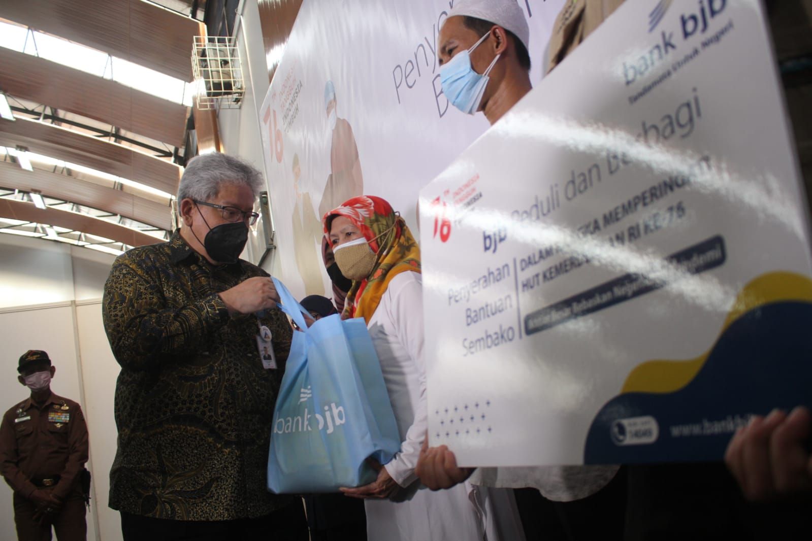 Direktur Utama Bank Bjb Yuddy Renaldy secara simbolis menyerahkan bantuan sosial dan paket sembako kepada warga terdampak COVID-19 pada kegiatan perayaan HUT RI ke-76, di GOR bank bjb, Jln. Naripan, Kota Bandung, Senin (16/8/2021).