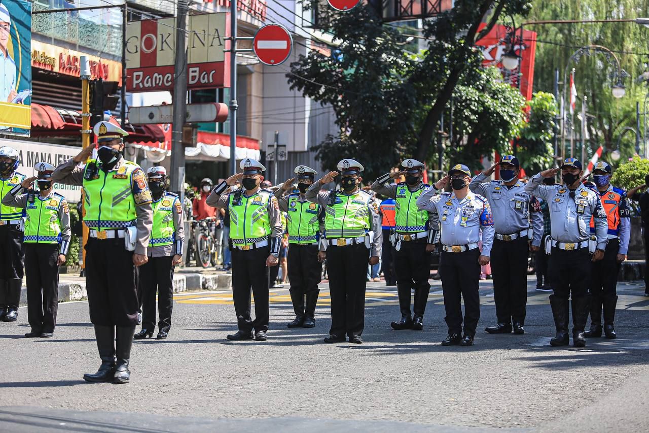 Anggota kepolisian dari Polrestabes Bandung dan Dishub Kota Bandung memimpin sikap sempurna di simpang Jalan Merdeka Kota Bandung hari ini Selasa, 17 Agustus 2021.