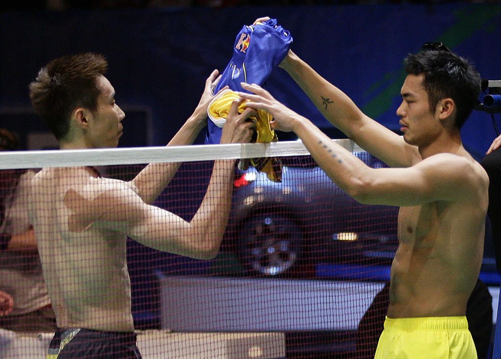Lee Chong Wei (L) of Malaysia shakes exchanges shirts with Lin Dan of China after retiring injured during the men's singles final match at the All England Badminton Championships in Birmingham, central England March 11, 2012. REUTERS/Darren Staples   (BRITAIN - Tags: SPORT BADMINTON)