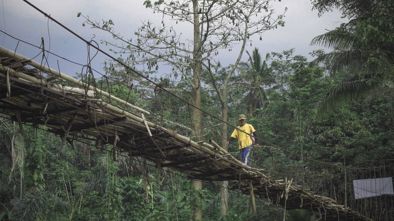 Warga berjalan di atas jembatan kayu di perbatasan Simpang – Kab. Garut dan Cempakasari – Kab. Tasikmalaya sebelum diperbaiki. Kondisi jembatan saat itu sangat mengkhawatirkan/Dok. Sinergi Foundation
