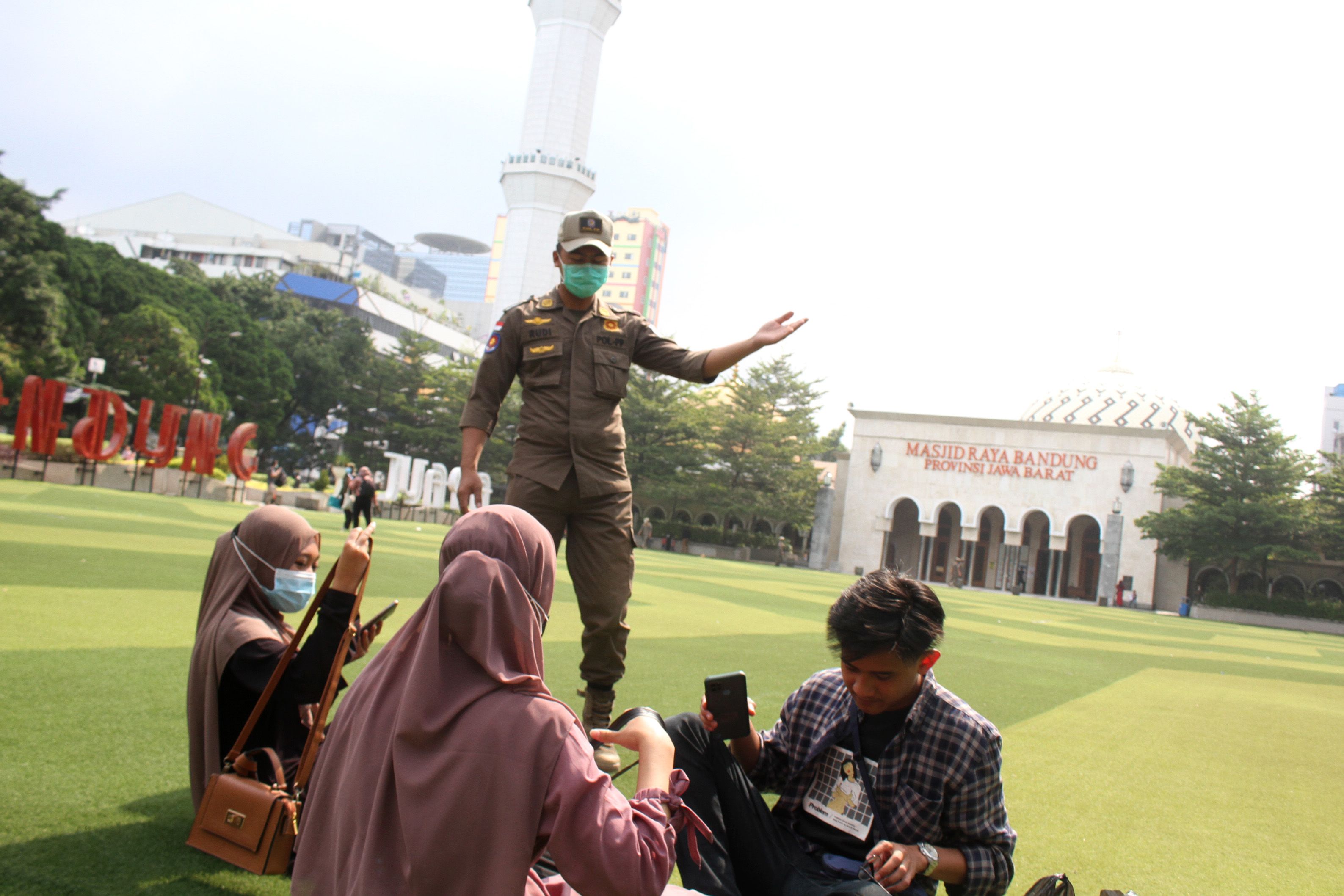 Petugas Satpol PP Kota Bandung memberi arahan kepada warga untuk di Taman Alun-alun Bandung, Jln. Dalem Kaum, Kota Bandung, Selasa, 7 September 2021./