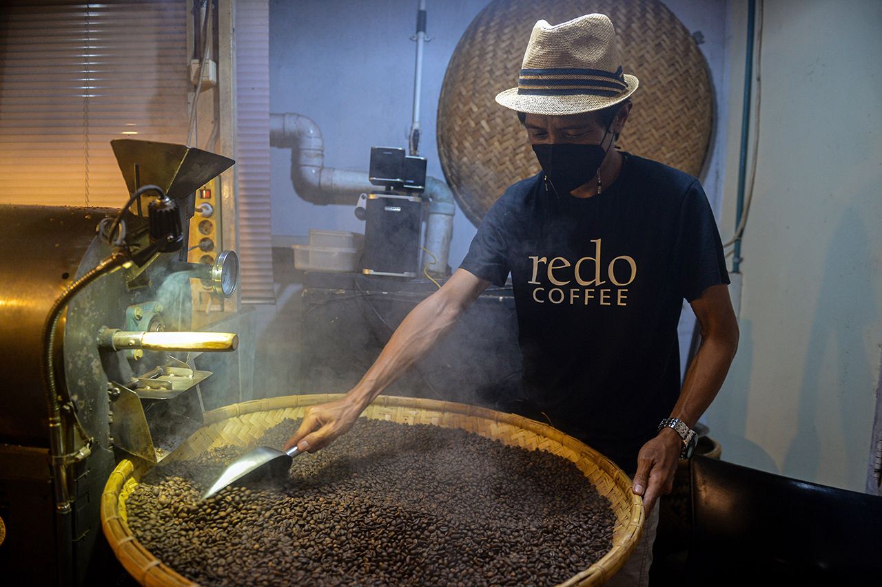 Pemilik usaha melakukan proses penggorengan kopi Koya di rumahnya di Kota Manado, Sulawesi Utara.