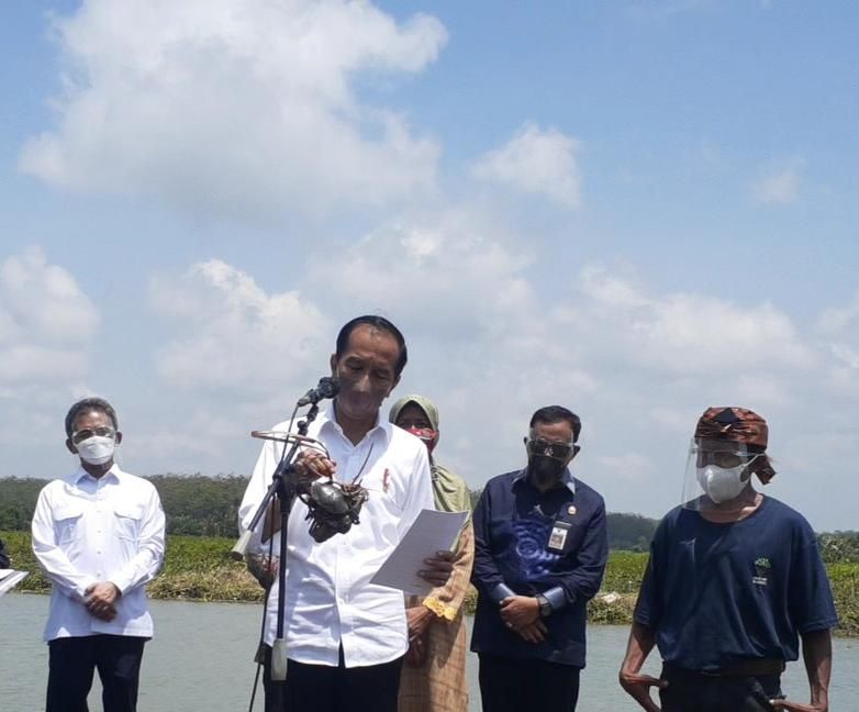 Presiden Jokowi memperlihatkan dua kepiting yang diberikannoleh nelayan di Cilacap