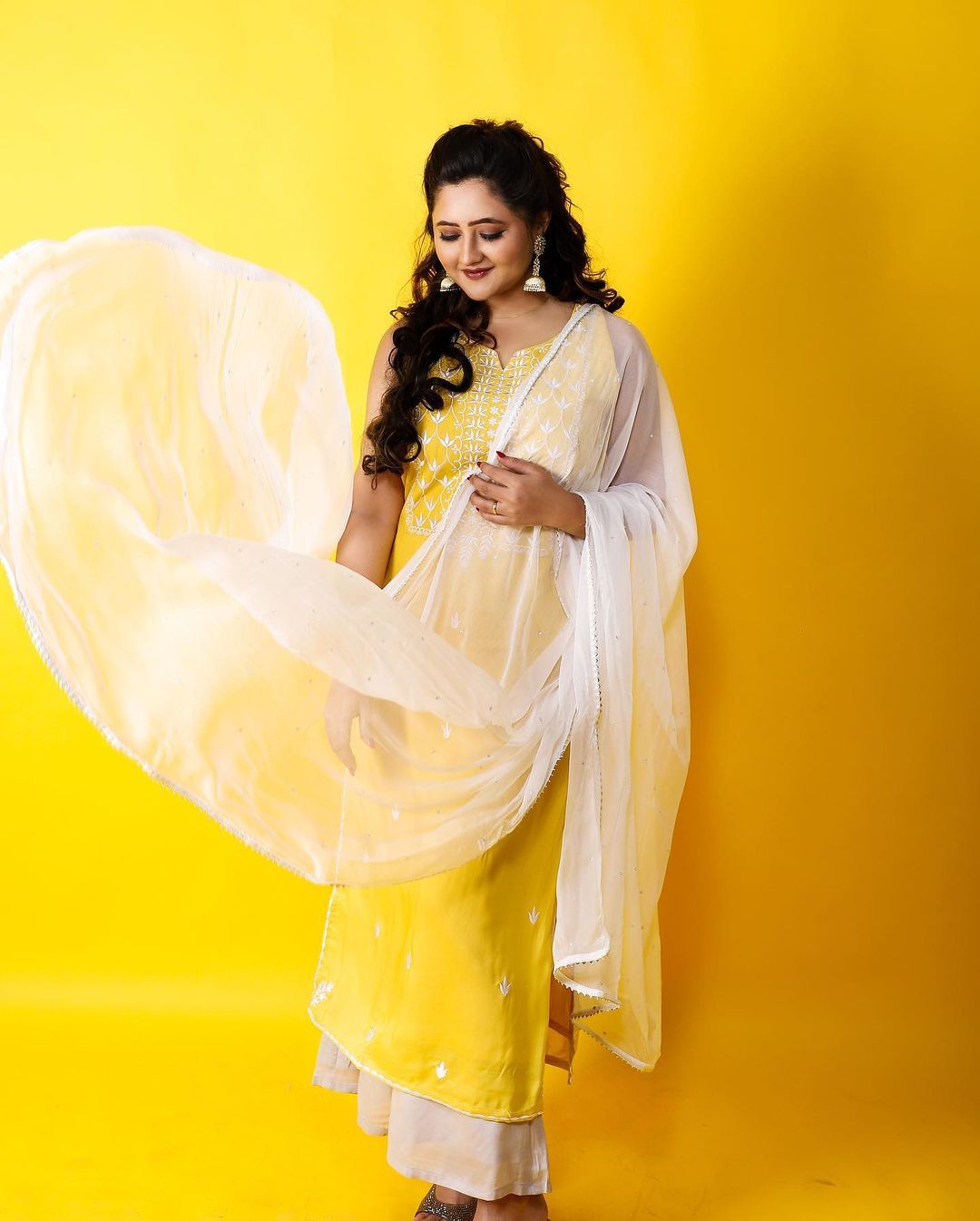 Selendang putih dalam balutan saree berwarna kuning membuat penampilannya terlihat menyegarkan.