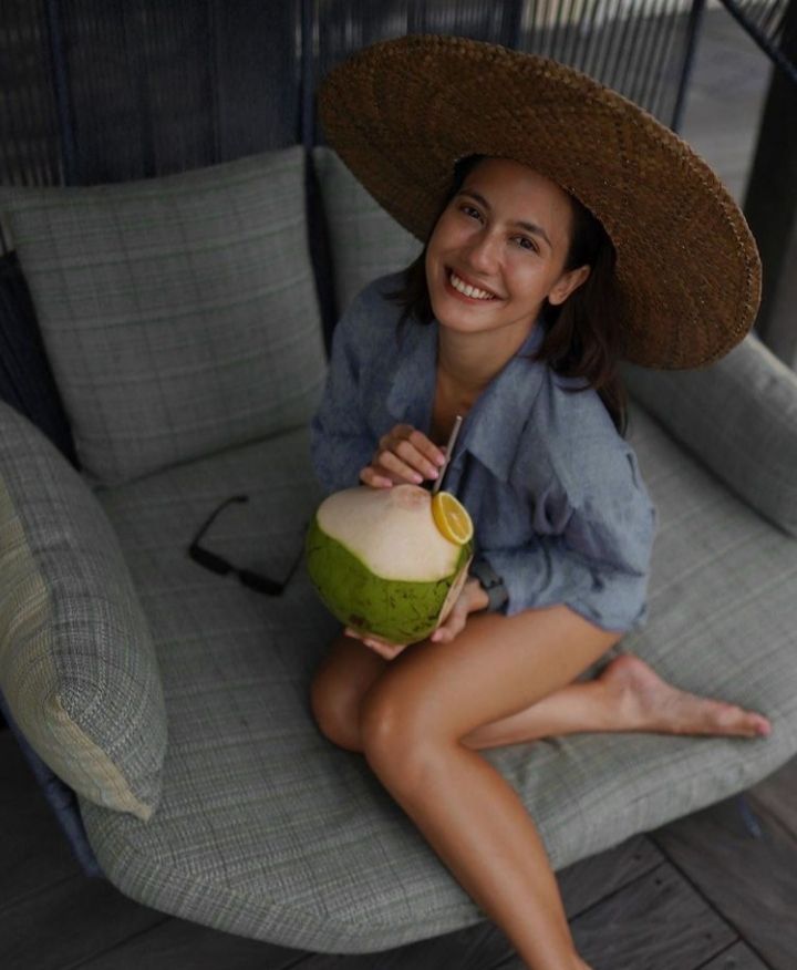Pose Pevita Pearce saat menyantap kelapa muda, munman khas pantai
