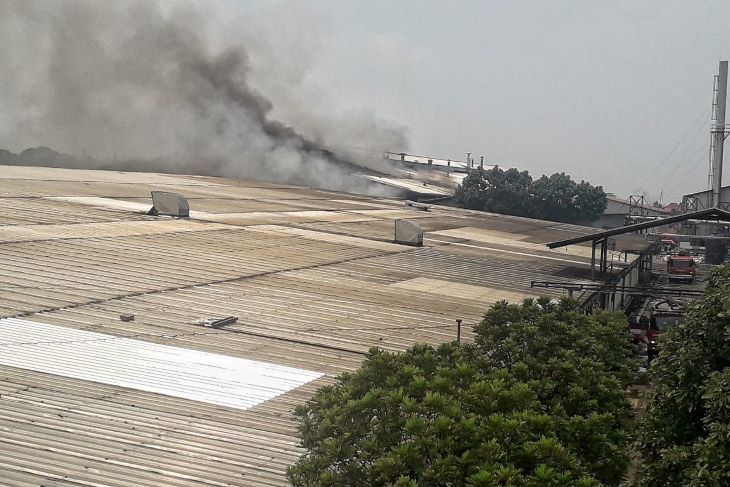 Asap mengepul dibagian atap pabrik garmen PT Gajah Angkasa Perkasa di Jalan Jenderal Sudirman yang terbakar sejak pukul 08.55 WIB.