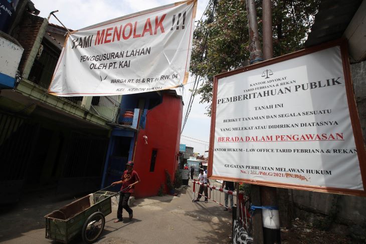 Baliho pengumuman kuasa hukum warga dan spanduk penolakan warga berdampingan di jalan masuk Jaan Anyer Dalam, Kelurahan Kebonwaru Kecamatan Batununggal Kota Bandung.
