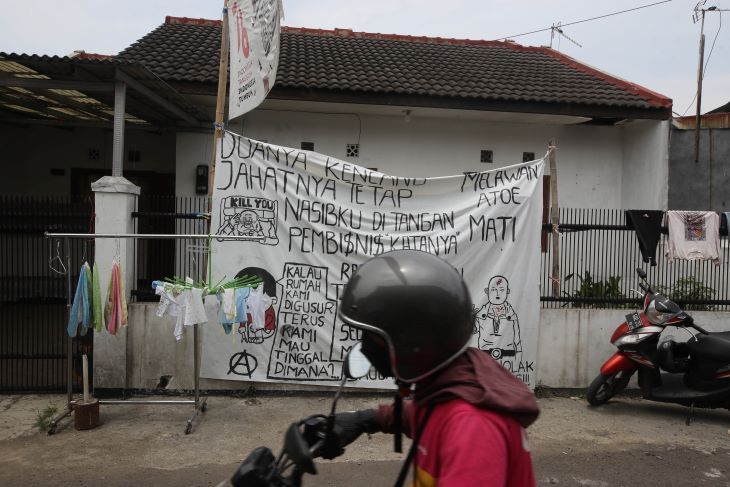 Warga melintas di depan rumah warga dengan baliho besar menolak penggusuran di Jalan Anyer Dalam Kelurahan Kebonwaru Kecamatan Batununggal Kota Bandung.