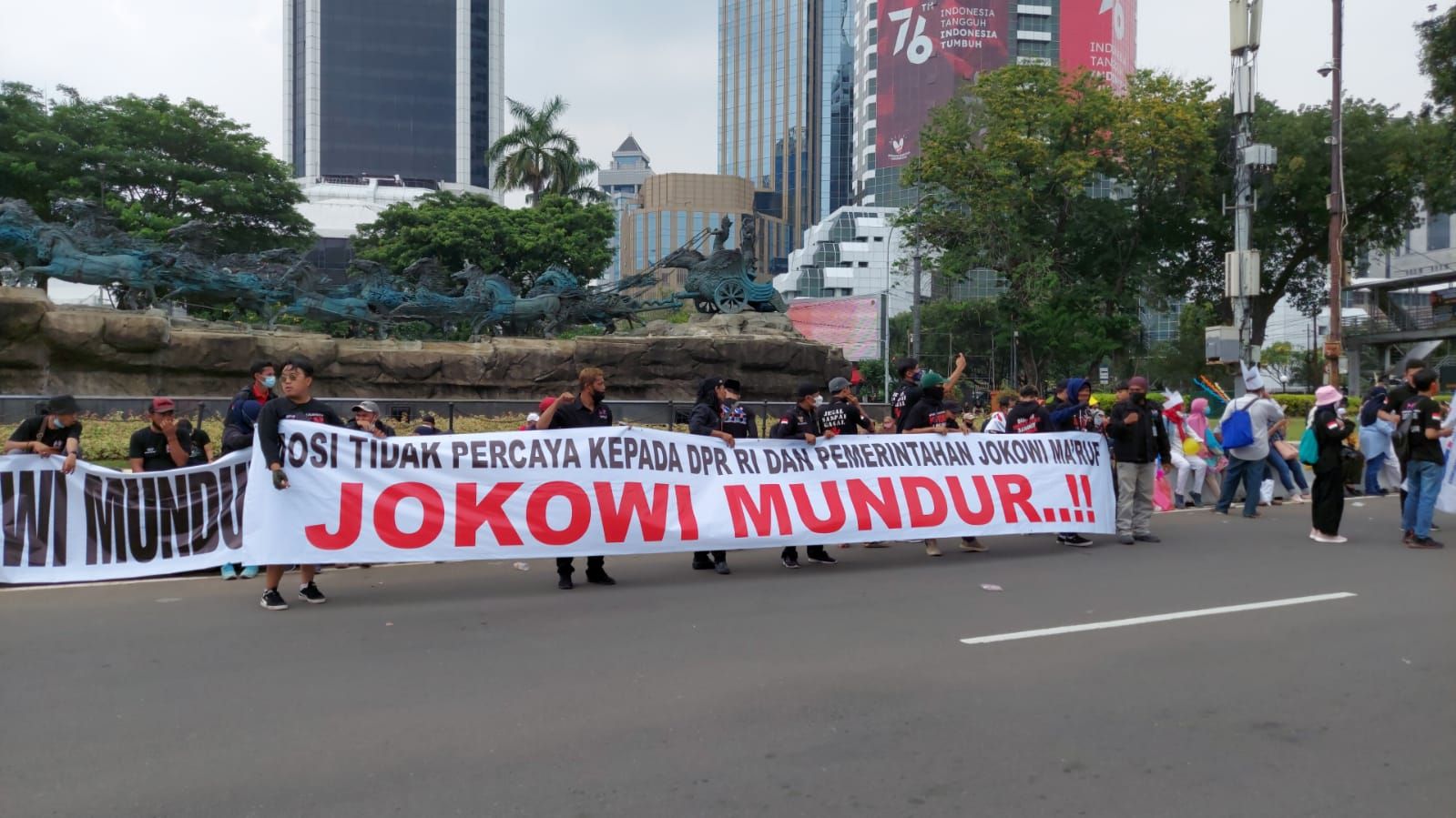 Massa demo di sekitar patung kuda Jakarta Pusat membentangkan spanduk Jokowi Mundur