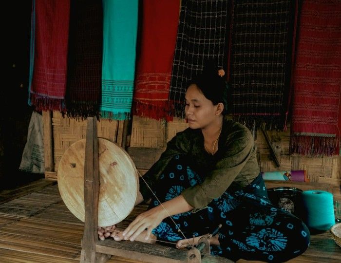 Perempuan Baduy sedang menggulung benang yang digunakan untuk membuat tenun Baduy.