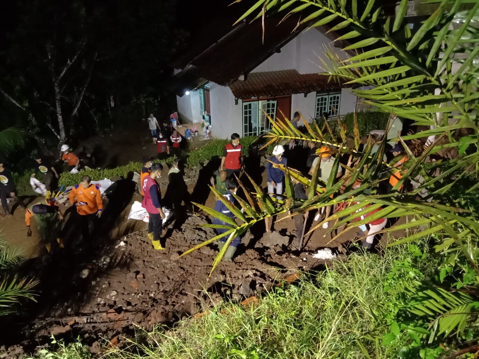 Relawan Gabungan membersihkan talud longsor yang menutupi Jalan Kabupaten penghubung Kecamatan Cilongok menuju Kecamatan Purwojati di Desa Jatisaba, Banyumas, hari Jumat 19 Nopember 2021. / Tagana Banyumas