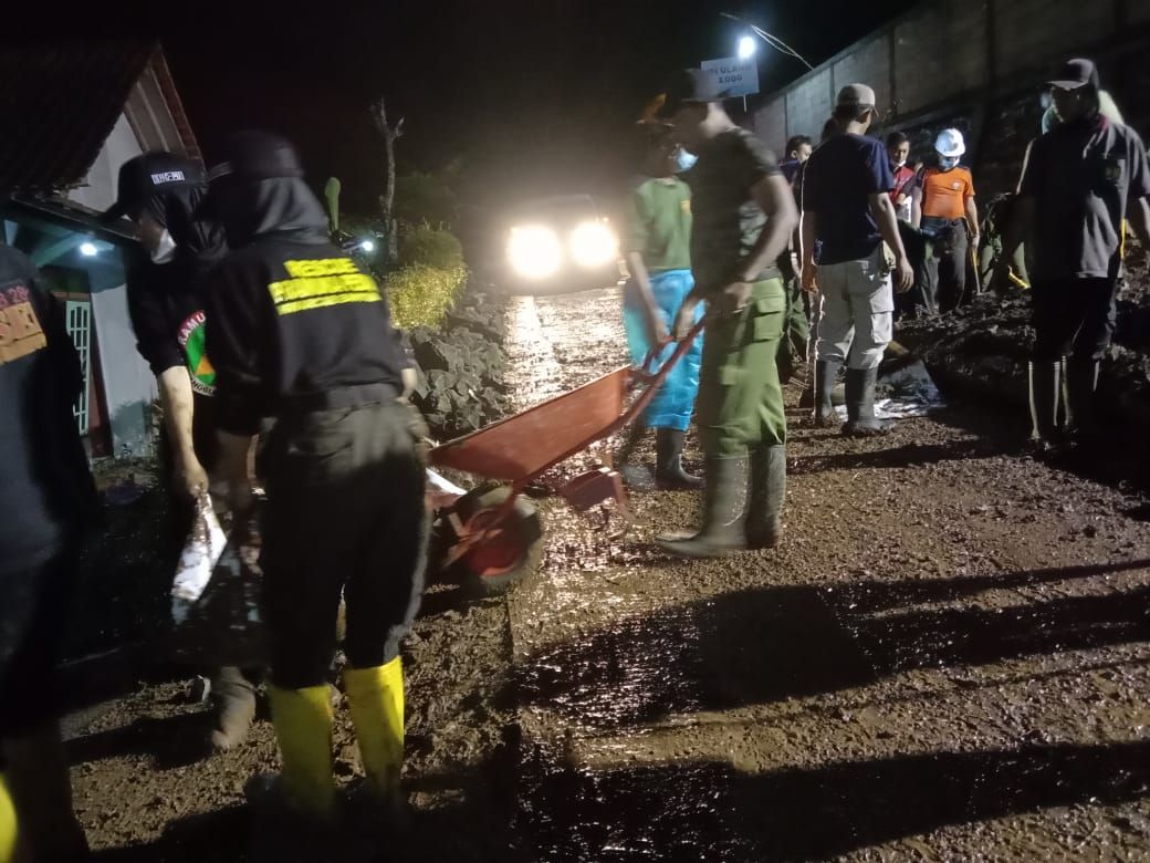 Relawan Gabungan membersihkan talud longsor yang menutupi Jalan Kabupaten penghubung Kecamatan Cilongok menuju Kecamatan Purwojati di Desa Jatisaba, Banyumas, hari Jumat 19 Nopember 2021. / Tagana Banyumas