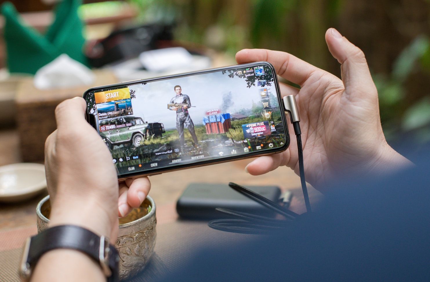  A person is holding a black gaming phone with a 6-inch Full HD display, an octa-core processor, 4GB of RAM, and a 4000mAh battery while playing a game.