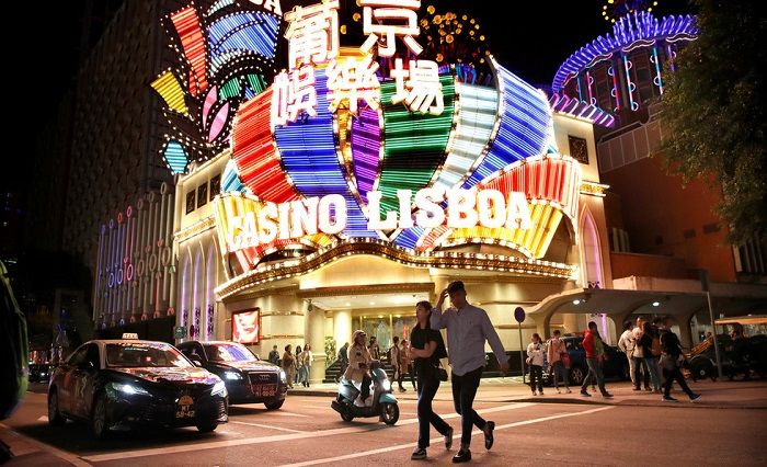 Orang-orang berjalan di depan Casino Lisboa di Macau, China.*  