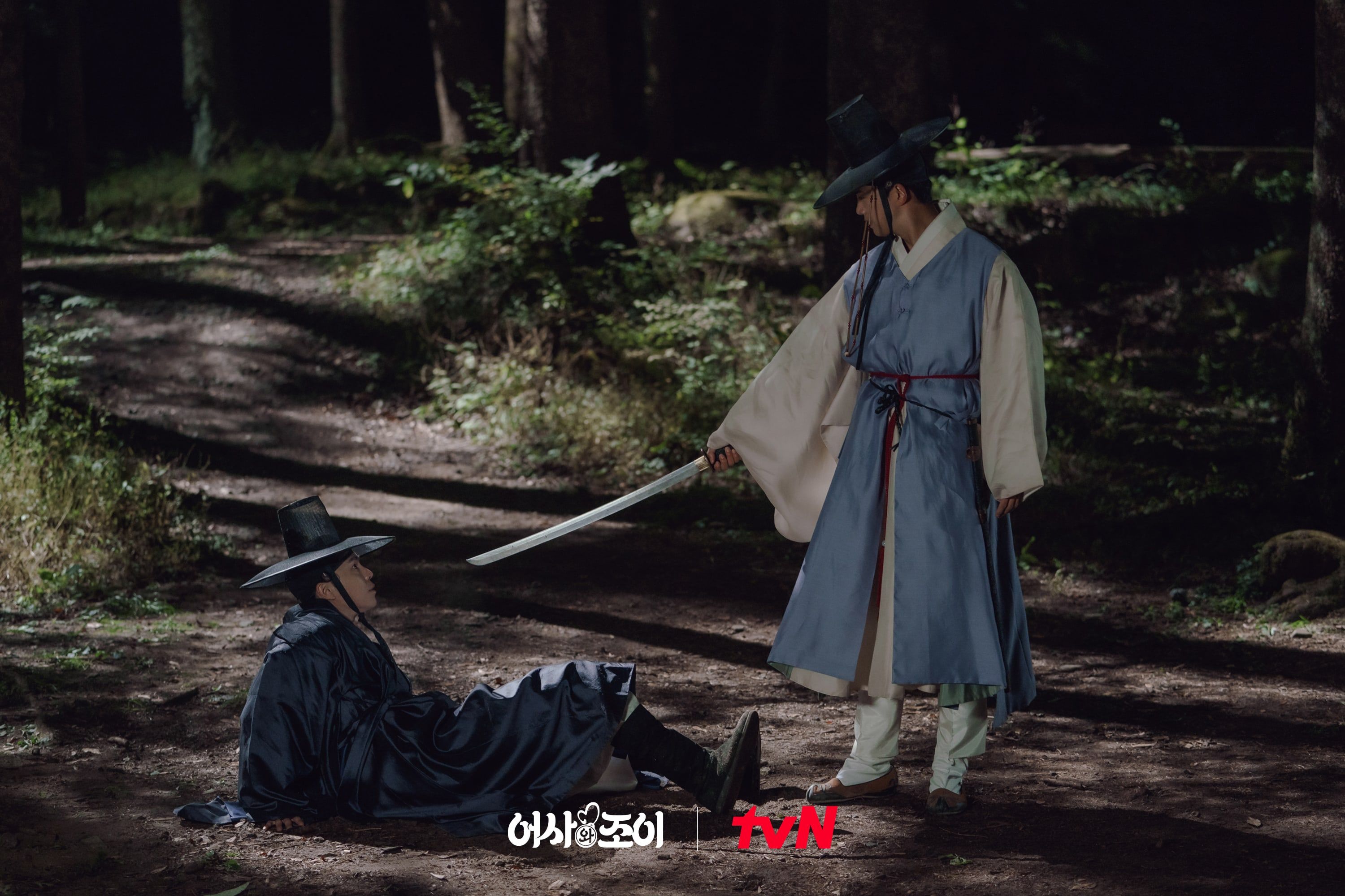 Ra Yi Eon mengacungkan pedangnya di hadapan Park Tae Seo yang jatuh. 