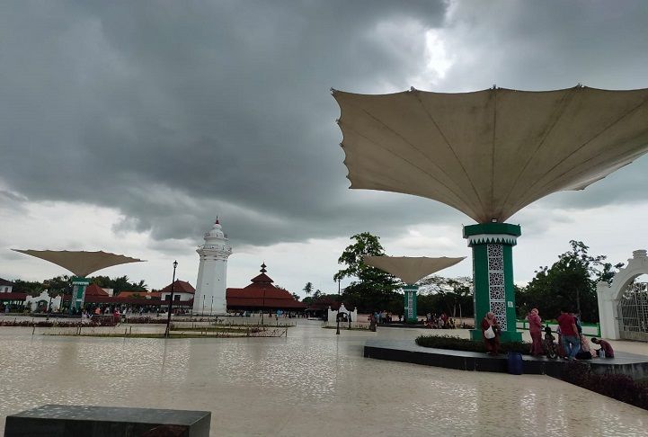 Sejumlah pengunjung tempat wisata di Kota Serang sedang berteduh di bawah payung raksasa di halaman Masjid Agung Banten Lama, Sabtu 15 Januari 2022. Berikut jadwal shalat untuk Banten dan sekitarnya pada Senin 3 Januari 2022