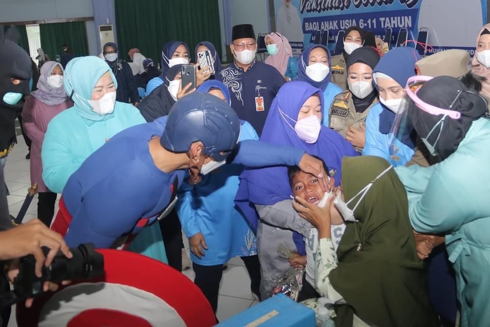 Aksi pria berkostum Captain America menenangkan peserta vaksinasi anak usia 6-11 tahun di Batam.