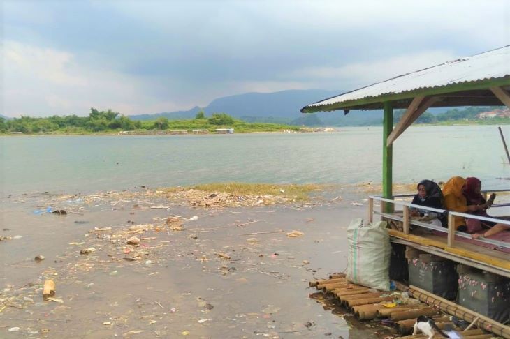 Pengunjung salah satu rumah makan di Desa Sukaratu Kecamatan Darmaraja Kabupaten Sumedang dengan latarbelakang sampah menutupi permukaan air bendungan Jatigede.