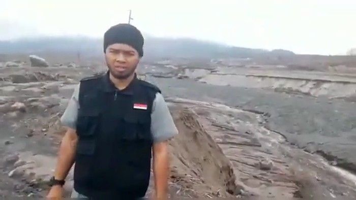 Pria penendang sesajen di daerah erupsi Gunung Semeru.